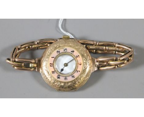 A ladies 14 carat gold half-hunter watch on 9 carat gold strap with salmon ground engine turned enamel chapter ring.