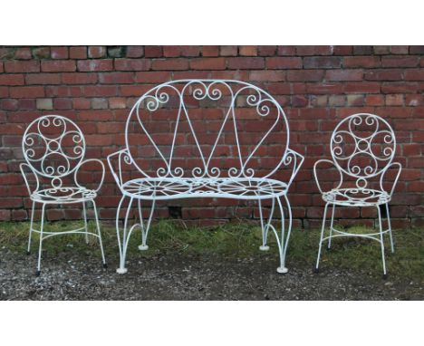 A painted wrought iron garden bench and a pair of chairs.