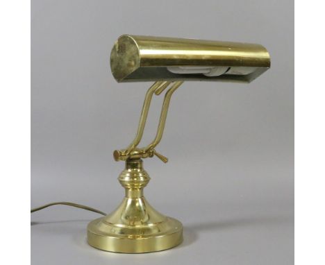 An adjustable brass desk lamp.