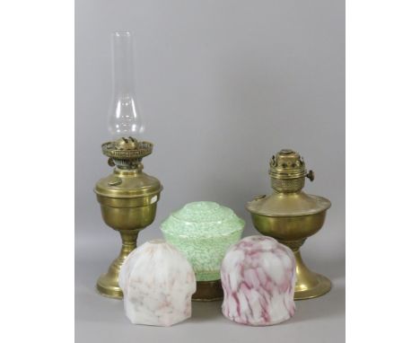 Two Victorian brass based oils lamps along with three coloured glass light shades.