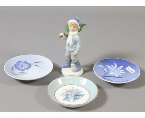 A Royal Copenhagen figure of a young boy carrying a Christmas tree, two Royal Copenhagen dishes and a Royal Worcester example