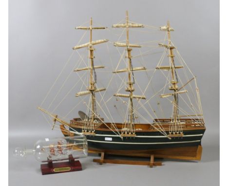 A wooden scale model of a three mast galleon along with a ship in a bottle.