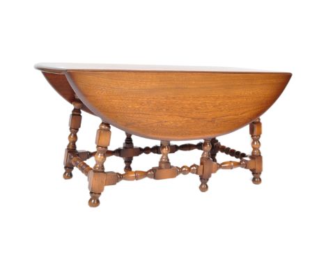 A retro vintage 20th century circa 1970's Ercol ' Old Colonial ' beech and elm wood drop leaf coffee table being raised on tu