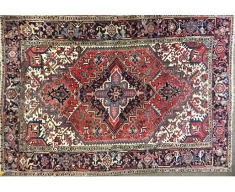 A vintage mid 20th century Persian Islamic Heriz hand knotted floor carpet rug having graduating central medallions with flor