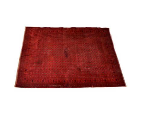 A large early 20th Century Persian floor carpet rug. Red ground with repeating geometric panel forming a large part of the su