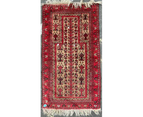 A vintage 20th Century Persian Islamic Baluch prayer floor carpet rug. Having central geometric panel with a series of repeat