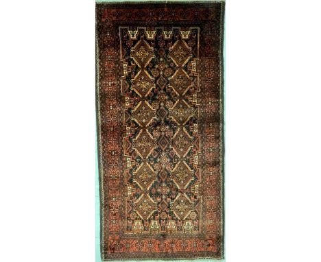 A 20th century North East Persian Islamic Turkoman floor rug carpet having dark earthy tones decorated with a central panel w