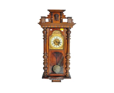 A 20th century walnut Viennese regulator hanging wall 8 day chime clock having a flared to with dentil decoration. The clock 
