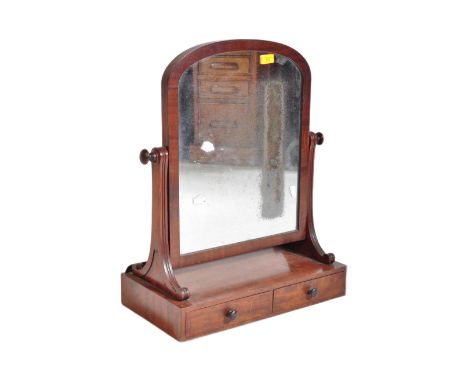 A 19th century mahogany toilet swing mirror. The mirror having arched top with ring turned target fittings to sides over scro