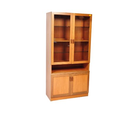 A Mid-Century G-Plan teak wood display cabinet bookcase. Raised on inset plinth base with twin door cupboard, open shelf with