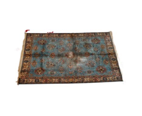 A large early 20th Century Persian floor carpet rug. Unusual turquoise ground with repeating decoration surrounded by geometr