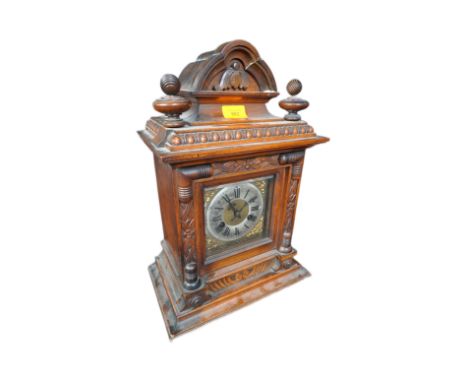 A late 19th century early 20th century believed German walnut mantel 8 day clock. The mantle clock having top side spindles o