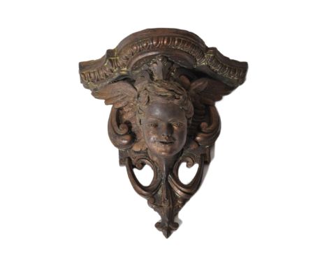 20th century cast metal wall mask - clock bracket&nbsp; of gothic ecclesiastical form. The bracket with winged cherub - putti