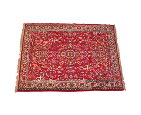 A 20th century Persian Heriz style rug. The rug having a red ground with arabesques and florals to centre and patterned borde