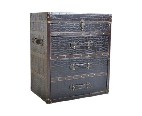 A contemporary leather studded travel chest of drawers. The travel trunk having a lift up top over three graduating drawers. 