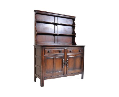 A mid century Ercol beech and elm wood dresser. Raised on stile legs with the base comprising of  a series of drawers and cup