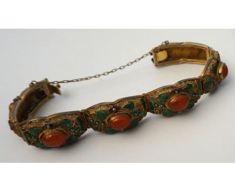 A silver gilt articulated bangle, with amber cabochons and green enamel leaves, early 20th century, 18cm long, marked ‘Silver