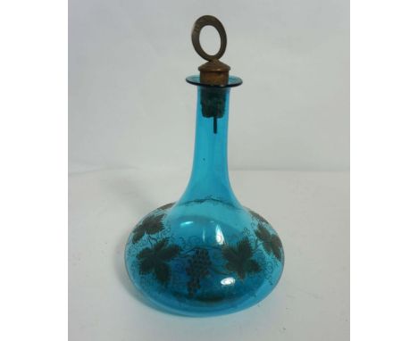 A George III light blue glass ships decanter, engraved with fruit of the vine and set with a brass topped stopper marked ‘Bra