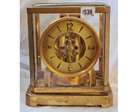 An Atlas brass mantel clock by LE COULTRE with circular dial. (Glass panel to top broken). 9.5" high.