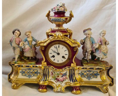 A decorative French porcelain mantle clock with 2 pairs of figures and white enamel dial. 17" wide.