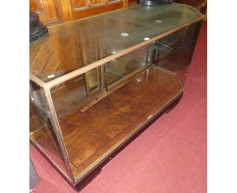 An Art Deco figured walnut, ebonised, brass and glazed shop display cabinet by Elliott &amp; Sons, with chamfered corner edge