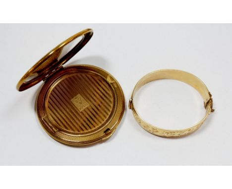 A metal core gold plated hinged bangle and a Kigu compact 