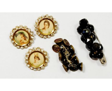 Three antique paste and lithograph buttons, a set of Victorian jet buttons and another set of mother of pearl buttons