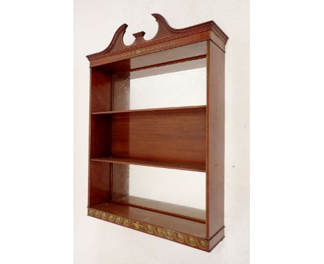 An Edwardian mahogany mirror back wall shelf with swan neck pediment and green painted classical decoration, 63cm wide x 96cm