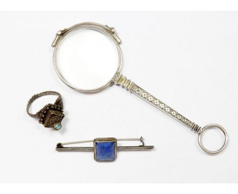 A white metal lorgnette, silver brooch and white metal ring 