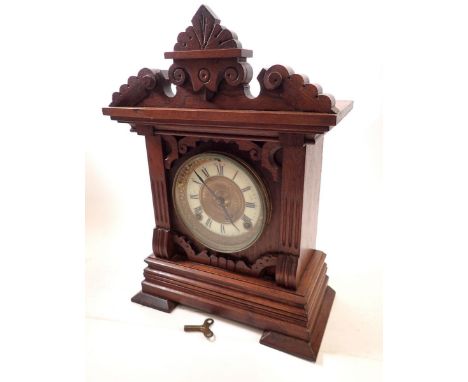 An American 19th century oak carved mantel clock with enamel chapter ring and carved case, 38cm tall 