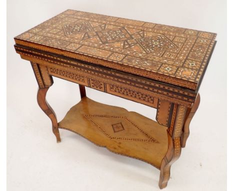 A Damascus marquetry fold top games table with card baize, backgammon and chess boards