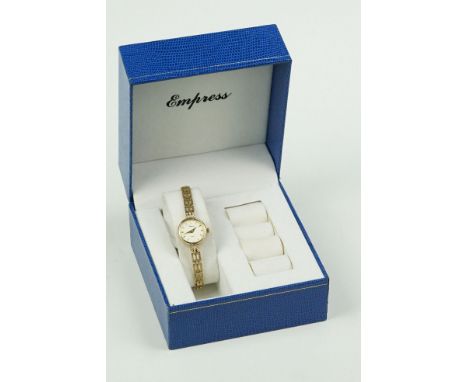 9ct Empress ladies wrist watch having a round gilt face with baton markers to the chapter ring mounted to a 9ct gold gate lin