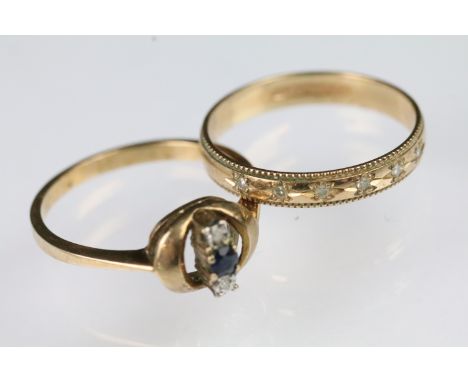 Two 9ct gold rings to include a ring with round pierced head set with a central sapphire flanked by two round cut sapphires (