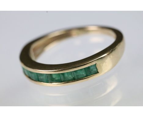 9ct gold and emerald ring being channel set with square step cut emeralds to the head. Hallmarked Sheffield. Size L.5. 