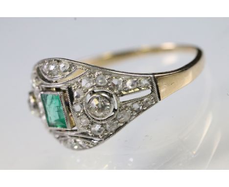 Art Deco emerald and diamond panel ring being set with a rectangular step cut emerald to centre flanked by two round old cut 