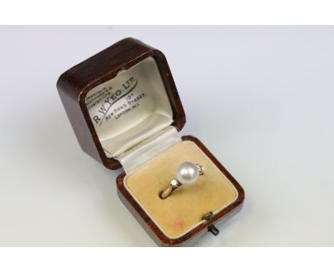 14ct gold, pearl and diamond ring. The ring being set with a central cultured pearl flanked by two round brilliant cut diamon