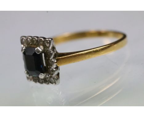 22ct gold and platinum sapphire and diamond halo ring. The ring being set with a rectangular step cut sapphire surrounded wit
