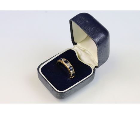18ct gold, sapphire and diamond ring. The ring being channel set with alternate step and princess cut diamonds and sapphires.