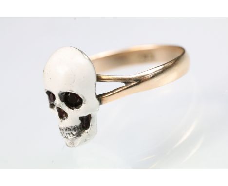 9ct gold and enamel skull ring. The ring being set with  a white enamelled skull to the head set with two round cut red stone
