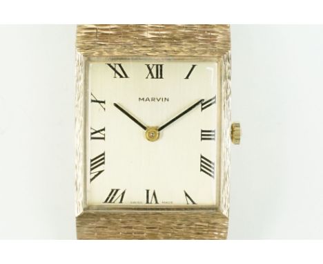 9ct gold Marvin vintage wrist watch having a rectangular face with roman numerals to the chapter ring mounted to a bark effec