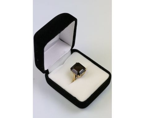 Vintage yellow metal and smoky quartz dress ring. The ring being set with a rectangular step cut smoky quartz in a basket set