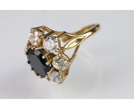 9ct gold sapphire and CZ dress ring. The ring being set with an oval cut blue sapphire surrounded by round cut CZ's. Hallmark