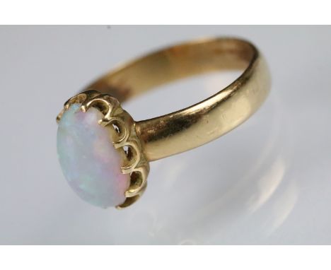 Yellow metal and opal solitaire ring. The ring being set with an oval opal cabochon set to a plain band. Band unmarked, tests