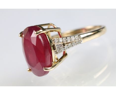 9ct gold ruby and diamond dress ring. The ring being set with an oval cut ruby in a four prong setting to the head with accen