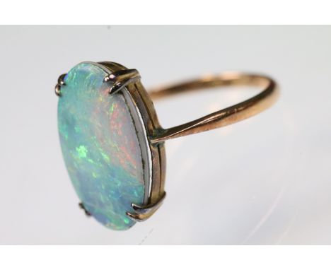 9ct gold and opal doublet panel ring. the ring being prong set with an oval opal doublet panel on plain band. Marked 9ct. Siz