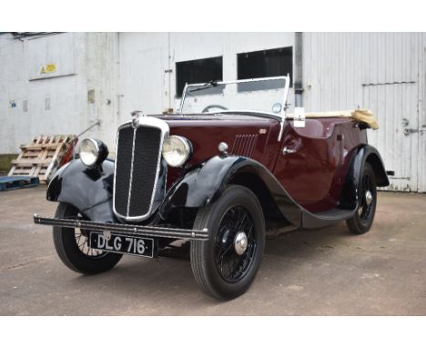 A 1936 Morris Eight tourer, registration number DLG 716, maroon over black. The well equipped Morris eight became available i