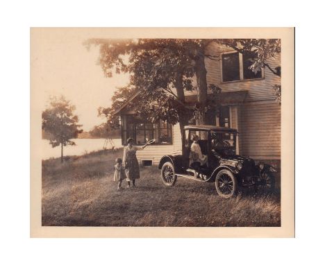 Black and white gelatine silver print photo depicting a family saying goodbyes to their relative, as he gets ready to leave i