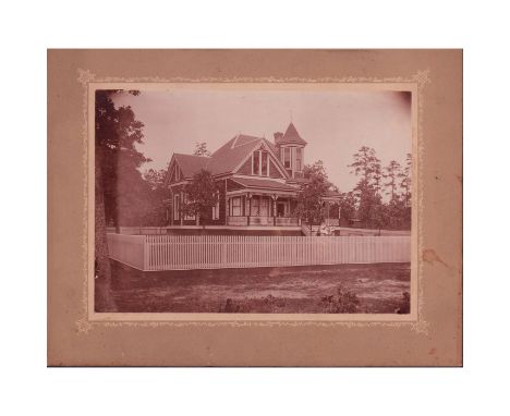 Antique black and white photo depicting a Queen Anne Style House with people dressed in early 20th century attire.White picke
