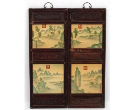 A large pair of Chinese ceramic panels in wooden frames, each having two panels decorated with rivers in mountainous Chinese 