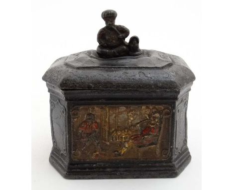 A lead tobacco box and tamper, with polychromed image of a figure smoking with a young Negro man servant and a finial of an O